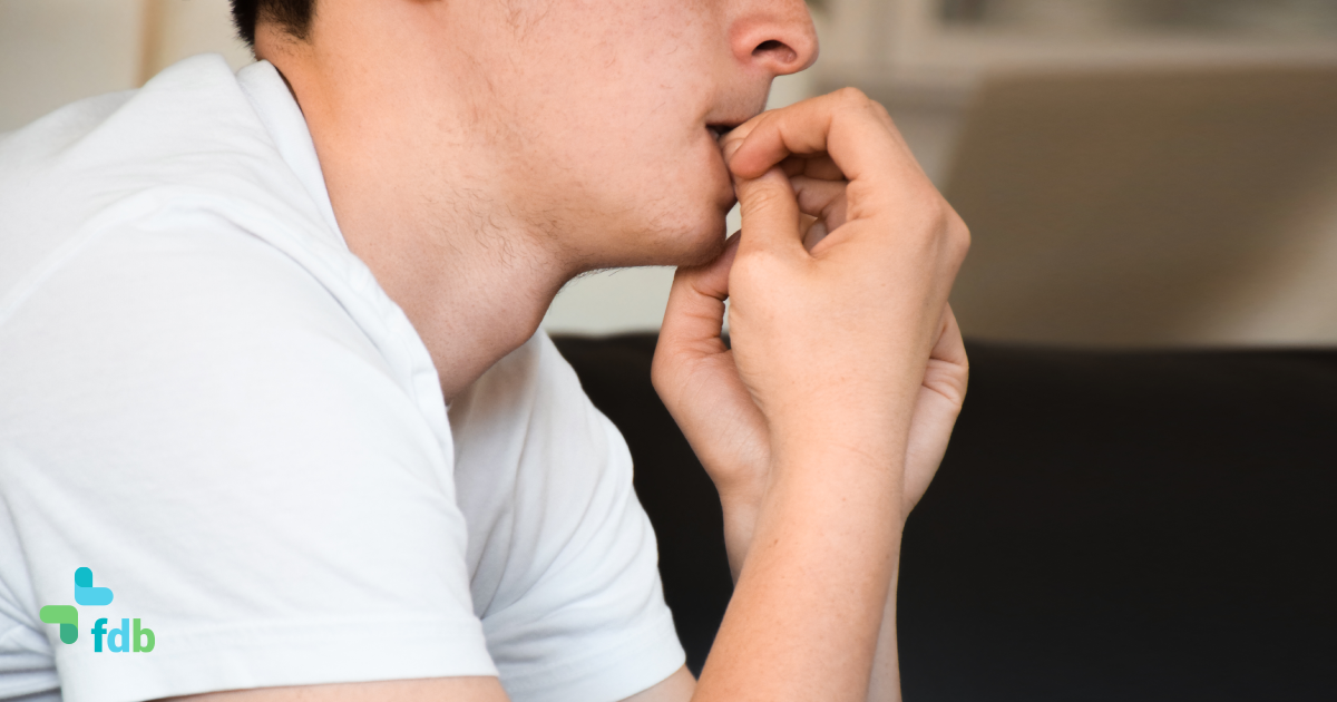 un uomo palesemente stressato mangia le unghie